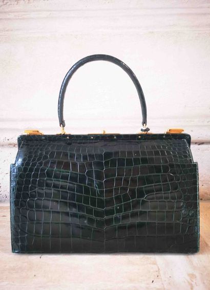 HERMES Sac mallette en crocodile vert foncé. L'intérieur en cuir vert à trois poches...