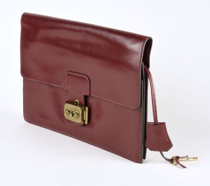 HERMES Pochette modèle Jet en veau Box bordeaux et garniture de métal doré. 

Tirette,...