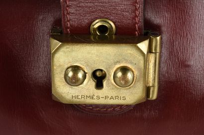 HERMES Pochette modèle Jet en veau Box bordeaux et garniture de métal doré. 

Tirette,...