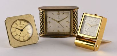 null Set of three travel alarm clocks: 

- YEMA alarm clock in gilt brass on quartz...