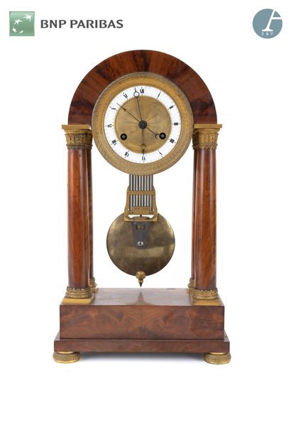 null Mahogany and gilt bronze clock with four columns resting on a rectangular base.
The...