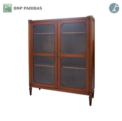null Bookcase in natural wood and veneer, opening with two glass doors, the filleted...
