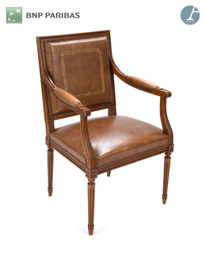 null A molded and carved natural wood armchair, gilded fawn leatherette trim,
Louis...