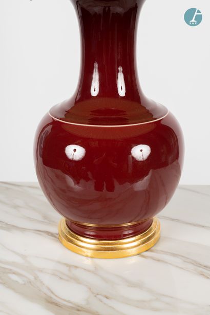 En provenance d'un prestigieux Palace parisien 
Vase mounted in a blood red enamelled...