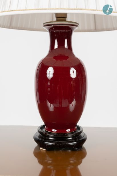 null 
Vase mounted in a blood red enamelled ceramic lamp, resting on a moulded wooden...
