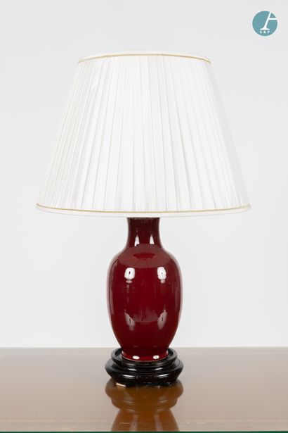 null 
Vase mounted in a blood red enamelled ceramic lamp, resting on a moulded wooden...