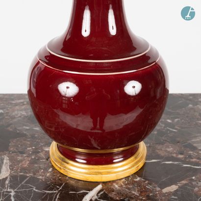 En provenance d'un prestigieux Palace parisien 
Vase mounted in a blood red enamelled...
