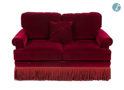 Un canapé deux places en velours rouge, à...