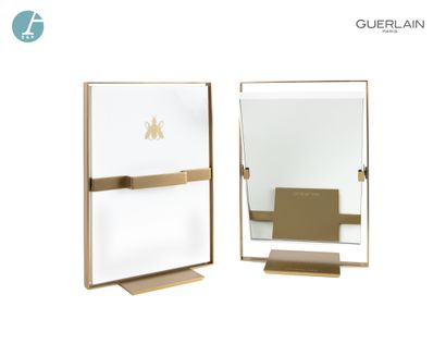 null Lot de deux miroirs pivotants, en métal doré et plastique blanc.

Logotés Guerlain....