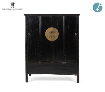 null Armoire en bois laqué noir, ouvrant à quatre porte, à décor d'un disque de laiton...