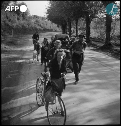 null 
AFP


Des réfugiés marchent sur une route de Normandie avec leurs affaires....