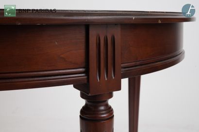 null Circular table in molded and carved dark walnut, resting on four tapered legs...