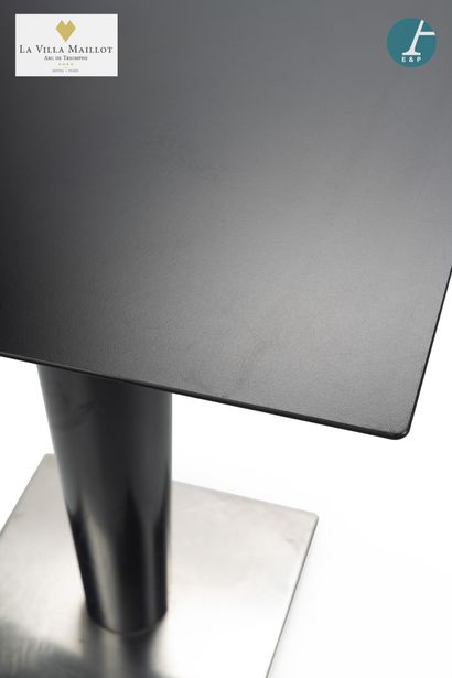 null Metal table, square top in black composition, resting on a central tubular upright...