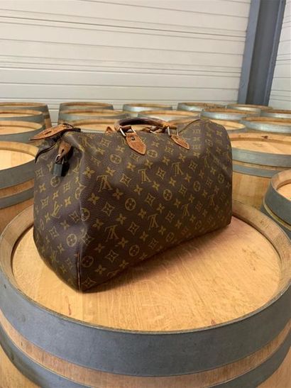 null LOUIS VUITTON. Sac à deux anses en toile monogrammé et cuir. Poignées usées...