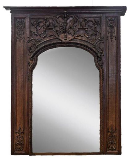 null IMPORTANT MIROIR de boiserie en bois mouluré et sculpté. Fronton aux attributs...