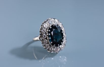 null MARGUERITE RING in 18 ct white gold set with a 6.25 ct oval green heated sapphire...