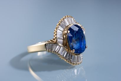 null 18 ct gold ring set with a large 5.96 ct oval Ceylon sapphire surrounded by...