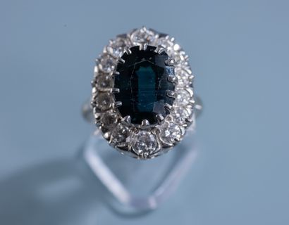 null MARGUERITE RING in 18 ct white gold set with a 6.25 ct oval green heated sapphire...