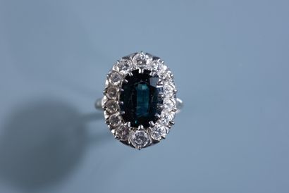 null MARGUERITE RING in 18 ct white gold set with a 6.25 ct oval heated green sapphire...