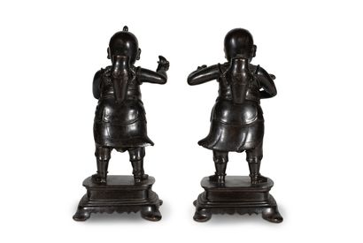  CHINE - XIXe siècle 
Deux enfants en bronze à patine brune, debout sur un socle...