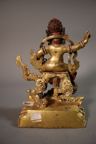 null TIBET, vers 1900	
Statuette de Jambhala blanc en bronze doré
assis sur un dragon...