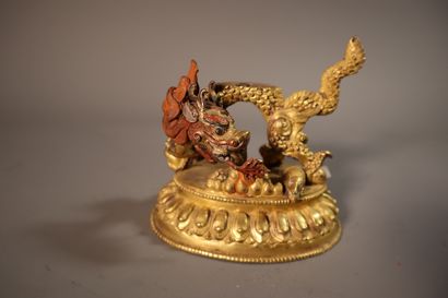 null TIBET, vers 1900	
Statuette de Jambhala blanc en bronze doré
assis sur un dragon...