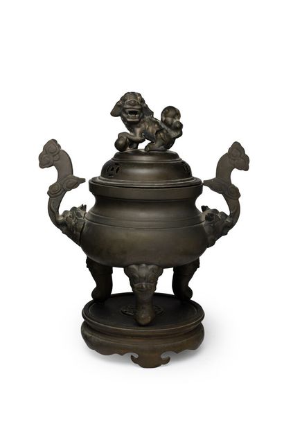 null VIETNAM, vers 1900	
Brûle-parfum tripode en bronze à patine brune
les anses...