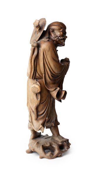 null CHINE, vers 1900	
Statuette de Liu Hai en bois debout sur un socle
tenant dans...