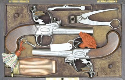 null Mahogany case lined with beige velvet containing a pair of flintlock pistols...