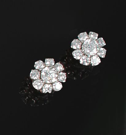 null PAIRE de BOUTONS d'oreilles en or ornée d'un diamant central de 0,5 ct au calibre...