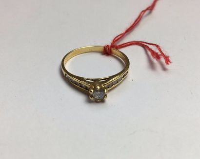 null Bague en or jaune 750, sertie d'un diamant taille brillant épaulé de petits...