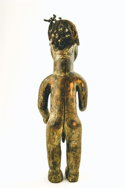 null STATUETTE masculine. Bois à patine brun clair, yeux incrustés d'un éclat de...