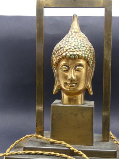 Lampe à tête de Boudha. Lampe en métal doré de forme quadrangulaire à tête de bouddha...