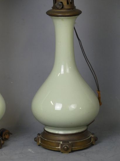 PAIRE DE LAMPES Paire de lampes à pétrole en porcelaine, couleur céladon. 

Un globe...