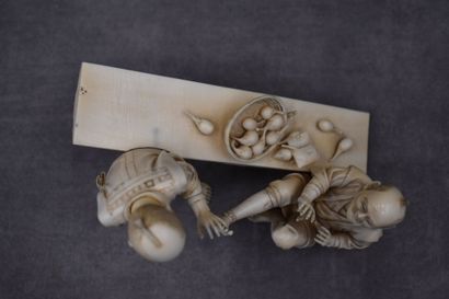 null JAPON. Okimono en ivoire aux deux personnages au banc et la corbeille de fruits....
