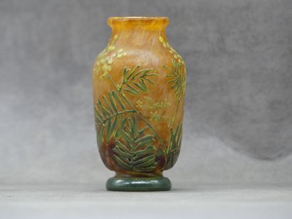 null DAUM. Petit vase en verre orangé à décor de mimosa vert. Piédouche et col évasé....