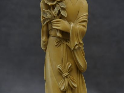 null CHINE. Okimono en ivoire sculpté d'une femme au bouquet de fleurs sur socle...