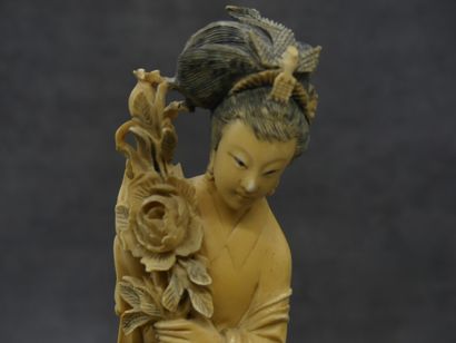 null CHINE. Okimono en ivoire sculpté d'une femme au bouquet de fleurs sur socle...