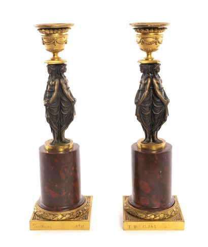 PAIRE DE BOUGEOIRS Paire de bougeoirs en bronze doré et patiné ornés de femmes drapées...
