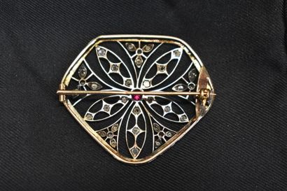 null Une broche or 750/°° et argent en forme de rosace. Au centre se trouve un rubis...