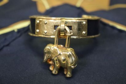 null HERMES. Bracelet en métal plaqué or et cuir, breloque figurant un éléphant,...