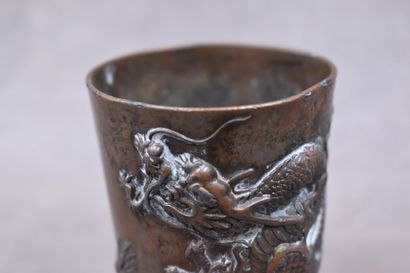 CHINE. Gobelet en bronze à patine brune à décor de dragons en relief. Hauteur : 8,8...
