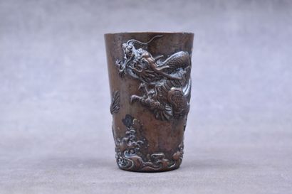 CHINE. Gobelet en bronze à patine brune à décor de dragons en relief. Hauteur : 8,8...