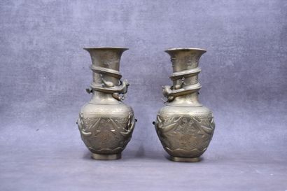 CHINE. Paire de vases en bronze à patine dorée à décor de dragons en relief. Signés...