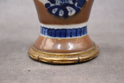 CHINE. Vase en porcelaine à décor de fleurs aux oiseaux, bronze ciselé et doré. Signé...