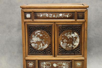 CHINE. Cabinet in molded and carved wood opening by two doors and a drawer in front,...