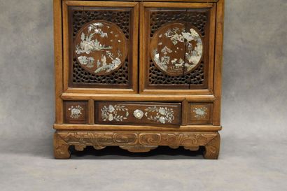 CHINE. Cabinet in molded and carved wood opening by two doors and a drawer in front,...