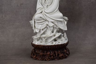 CHINE. Seated porcelain divinity on a wooden base. Marked with a double stamp. Total...