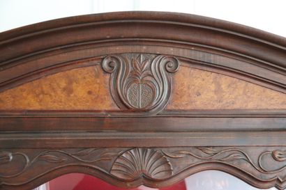 null Molded and carved wood showcase opening by two doors in belt. Surmounted by...