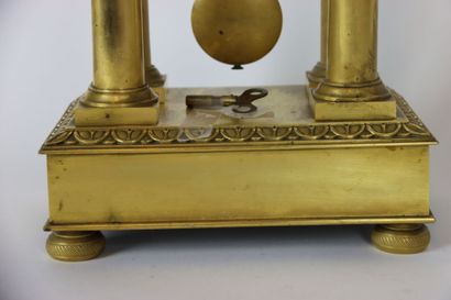 null Pendule portique en bronze doré, le cadran émaillé blanc à chiffres romains...